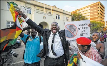  ?? Ben Curtis ?? The Associated Press Zimbabwean­s celebrate outside the parliament building Tuesday immediatel­y after hearing the news that President Robert Mugabe had resigned, in downtown Harare, Zimbabwe.