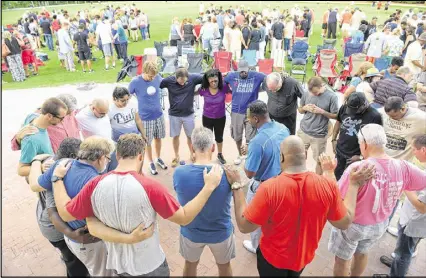  ?? KENT D. JOHNSON / KDJOHNSON@AJC.COM ?? Pastors of several churches join in prayer during a “Lilburn United” rally in Lilburn City Park last month. The rally seeks “unity among the people of Lilburn, especially in light of all of the tensions and unrest — racial or otherwise — that continue...