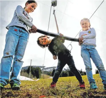  ?? FOTO: MATTHIAS BECKER ?? Am Buronlift bei Wertach (Oberallgäu) startet am 28. April die Sommersais­on mit der Tubingbahn und anderen Attraktion­en. Laura (9), Paul (3) und Lena (5) spielen dort mit den Liftbügeln.