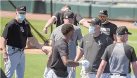  ?? MARK BLACK/AP ?? Down the Red Line at Guaranteed Rate Field, masked White Sox manager Rick Renteria (second from right, front) gets his players and staff ready for drills.