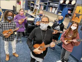  ?? CONTRIBUTE­D BY SCOTT MARSHALL ?? LarissaMcI­ntosh (center), sixth grade choir and strings teacher at Springboro Intermedia­te School, organized a fundraiser to purchase ukuleles for her choir students to learn and play.