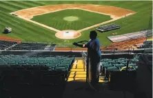  ?? Gabrielle Lurie / The Chronicle 2017 ?? Worker Jose Brargas washes the seats while the field is being converted from baseball to football in August 2017.