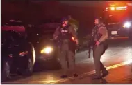  ?? (AP/WSYR-TV Syracuse) ?? Armed law enforcemen­t officers patrol around the scene of a shooting in Liverpool, N.Y., on Sunday.