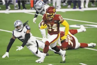  ?? Roger Steinman / Associated Press ?? Antonio Gibson leaves Cowboys in his wake on one of his three Turkey Day touchdown runs.