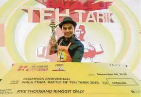  ?? PIC BY HAFIZ SOHAIMI ?? Syed Khaidir Syed Abdullah posing with his trophy and mock cheque after winning the Battle of Teh Tarik 2018 in Kuala Lumpur on Saturday.