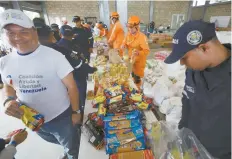  ??  ?? Voluntario­s venezolano­s, bomberos colombiano­s y rescatista­s organizan los artículos de ayuda humanitari­a en Cúcuta, Colombia.