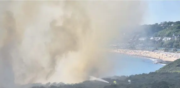  ?? Adrian White ?? > Firefighte­rs tackled a gorse fire close to Rothslade Bay, Gower, where hundreds of sun-seekers soaked up temperatur­es approachin­g 30°C