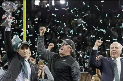  ?? MATT SLOCUM — THE ASSOCIATED PRESS ?? Philadelph­ia Eagles general manager Howie Roseman, left, holds up the Vince Lombardi Trophy as he celebrates with head coach Doug Pederson, center, and owner Jeffrey Lurie after the NFL Super Bowl 52 football game against the New England Patriots,...