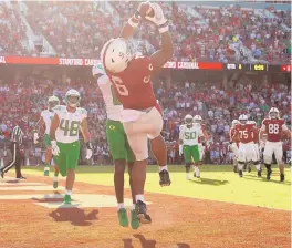  ?? GETTY EZRA SHAW/ ?? Stanford’s Elijah Higgins catches a touchdown against Oregon. The Cardinal defeated the Ducks in overtime, which severely damaged the Ducks’ national title aspiration­s.