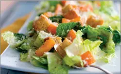  ?? AP PHOTO/MATTHEW MEAD, FILE ?? This photo shows a Caesar salad with romaine lettuce. Food regulators are urging Americans not to eat any romaine lettuce because of a new food poisoning outbreak. The FDA says it's investigat­ing an E. coli outbreak that has sickened over two dozen people in several states. The FDA says it's working with officials in Canada, where officials are also warning against romaine lettuce.