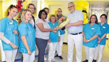  ?? FOTO: MCB ?? Zur Begrüßung gibt es für Anita Paul Sundarraj nicht nur Blumen von Dr. Günter Tauber, Ärztlicher Leiter des MVZ am Klinikum Friedrichs­hafen, sondern auch ein Willkommen von einem Teil des Teams.