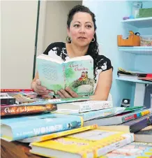  ?? JIM WELLS ?? Barb Silva of Support Our Students glances through some of her children’s books. She says lack of government funding for libraries has created inequaliti­es between Calgary schools.