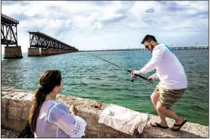  ?? The New York Times/SCOTT MCINTYRE Tyler Burke (right) and Kelsey Turner fish near a rail bridge while visiting Bahia Honda State Park on Bahia Honda Key, Fla. ??