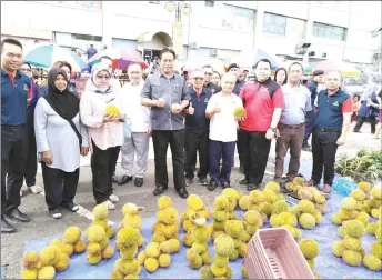  ??  ?? (From front fourth left) Dr Abdul Rahman and Batu Danau assemblyma­n Paulus Gumbang pose with yellow durians, a favourite of Bruneians.