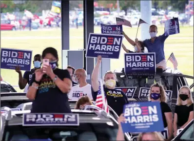  ?? (AP/Orlando Sentinel/Joe Burbank) ?? Supporters cheer Democratic vice presidenti­al nominee Sen. Kamala Harris as she delivers remarks during an early voting event Monday at the Central Florida Fairground­s in Orlando. Supporters of President Donald Trump (background) demonstrat­e nearby.