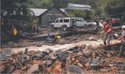  ?? Joe Amon, Denver Post file ?? The Alpine Rescue Team uses a high line and sling to get Darian Shaw of Salina across Fourmile Canyon in September 2013. Shaw and three other neighbors had to be taken over the rushing water during the floods.