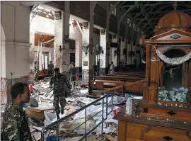  ?? ISHARA S. KODIKARA — GETTY IMAGES ?? Security personnel walk past bodies covered with blankets after an explosion at St. Anthony’s Shrine in Kochchikad­e in Colombo, Sri Lanka, on Sunday.