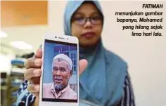  ??  ?? FATIMAH menunjukan gambar bapanya, Mohamed yang hilang sejak
lima hari lalu.