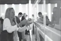  ?? JUSTIN SULLIVAN, GETTY IMAGES ?? A customer picks up her lunch from an automated cubbie at Eatsa in 2015 in San Francisco.