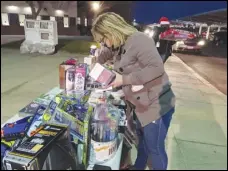  ?? JULIE DRAKE/VALLEY PRESS ?? Los Angeles County social worker Viola Orr selects an age-appropriat­e gift for a youth serviced by the Los Angeles County Department of Children and Family Services during a drive-thru event Thursday night at Lancaster Municipal Stadium.