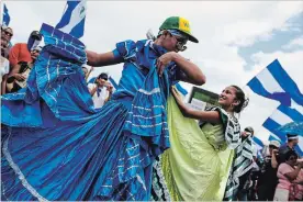  ?? CRISTOBAL VENEGAS
THE ASSOCIATED PRESS ?? Anti-government demonstrat­ors in folkloric dresses dance during a march in Managua on Saturday demanding the ouster of Daniel Ortega and the release of political prisoners.