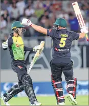  ??  ?? Australia’s Alex Carey (L) and Aaron Finch (R) celebrate their win during the Twenty20 Tri Series match against New Zealand at Eden Park in Auckland on Friday.