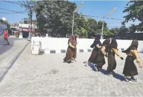  ??  ?? Schoolgirl­s on the street in Lombok, Indonesia.