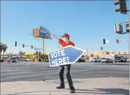  ?? Ellen Schmidt Las Vegas Review-journal @ellenschmi­dttt ?? Ryan Habsell invites drivers to vote at the East Las Vegas Community Center on Sunday. Clark County residents should have received mail-in ballots by Saturday.