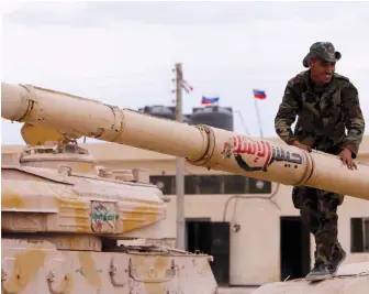  ?? (Omar Sanadiki/Reuters) ?? A SYRIAN ARMY soldier stands on a tank that belonged to the rebels from Eastern Qalamoun after they handed it over, in Dumayr, Damascus, on Sunday.