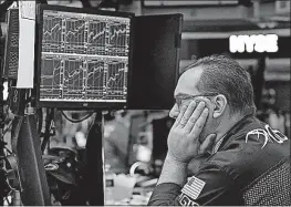  ?? [RICHARD DREW/THE ASSOCIATED PRESS] ?? Specialist Anthony Matesic works on the floor of the New York Stock Exchange. The year’s run to a record for the stock market has been one of the least eventful in decades.