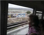  ?? AP PHOTO/HANS-MAXIMO MUSIELIK ?? A Central American child who is traveling with a caravan of migrants, peers at the border wall from a bus carrying the group to a gathering of migrants living on both sides of the border, in Tijuana, Mexico, on Sunday.