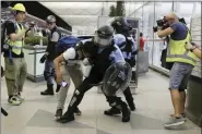  ?? KIN CHEUNG - THE ASSOCIATED PRESS ?? Policemen in riot gears arrest a protester during a demonstrat­ion at the Airport in Hong Kong, Tuesday. Chaos has broken out at Hong Kong’s airport as riot police moved into the terminal to confront protesters who shut down operations at the busy transport hub for two straight days.