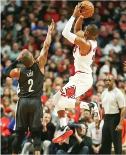  ?? (Reuters) ?? CHICAGO BULLS guard Dwyane Wade goes up over the Brooklyn Nets’ Randy Foye for two of his 16 points in the Bulls’ 101-99 home victory over the Nets on Wednesday night.