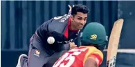  ??  ?? The UAE’s Qadeer Ahmed bowls to a Zimbabwe batsman.