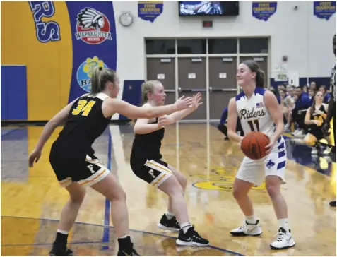  ?? Staff photo/Mike Frank ?? Kendall Dieringer of St. Marys holds the ball as she is guarded by two players from Fairview. The Lady Riders travel to Celina tonight for the first WBL game of the year.