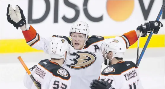  ?? LARRY MACDOUGAL/THE CANADIAN PRESS ?? Ducks forward Corey Perry, centre, celebrates Shea Theodore’s third-period goal Monday during Anaheim’s 5-4 overtime victory over the Flames.