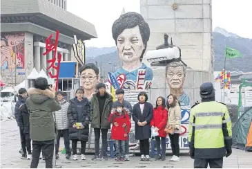  ?? AP ?? South Koreans pose in front of effigies of impeached President Park Geun-hye, centre, Hyundai Motor’s chairman Chung Mong-koo, right, and Samsung Electronic­s’ vice chairman Lee Jae-yong in Seoul.