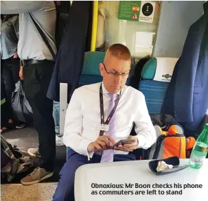  ??  ?? Obnoxious: Mr Boon checks his phone as commuters are left to stand