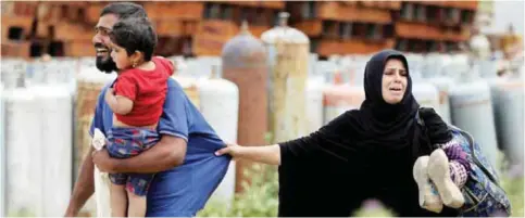  ??  ?? MOSUL: Displaced Iraqis from the Al-Haramat neighborho­od north of Mosul react after leaving their home as Iraqi forces advance towards the area during the ongoing offensive to retake Mosul from Islamic State (IS) group fighters yesterday. — AFP