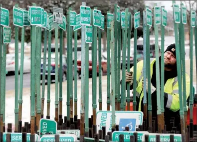  ?? Arkansas Democrat-Gazette/MITCHELL PE MASILUN ?? Kevin Brown, a member of the grounds maintenanc­e crew at the state Capitol, organizes parking signs Friday in preparatio­n for the legislativ­e session that begins Monday.