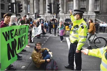  ??  ?? Climate change activists block traffic by Threadneed­le street in central London during environmen­tal protests by the Extinction Rebellion group in London. — AFP photo