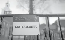  ?? Mark Makela / Getty Images ?? A sign keeps out visitors at the shuttered Independen­ce Hall in Philadelph­ia after the government shutdown. Some national parks were still accessible Saturday but with limited facilities.