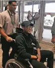  ?? FOTO: AP ?? Fußballer Neymar (r.) kommt im Rollstuhl am Flughafen in Rio an.