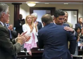  ?? SCOTT KEELER — TAMPA BAY TIMES VIA AP ?? Rep. Jose Oliva, R- Miami Lakes, is hugged and congratula­ted by House members as the gun and school safety bill passed the Florida House 67-50in Tallahasse­e, Fla., Wednesday. Oliva shepherded the bill through the House.