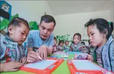  ?? PROVIDED TO CHINA DAILY ?? Yang Ming gives a painting class to children at a kindergart­en in Qianxi county, Guizhou province, in 2018.