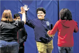  ?? Mark Mulligan / Staff photograph­er ?? Roberson Middle School seventh-grader Pablo Del Castillo high-fives his engineerin­g teacher Christine Pharris after seeing how far the mouse trap-powered car his team built traveled.