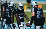  ?? BRIAN WESTERHOLT — THE ASSOCIATED PRESS ?? Las Vegas Raiders running back Josh Jacobs, center, flexes after one of his three touchdowns against the Panthers.