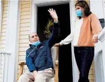  ??  ?? Chris Ward waves to neighbors from the front porch with his wife, Kate.