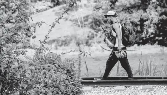  ?? Foto: Isabel Mateos / Cuartoscur­o. ?? > 29 de marzo de 2021. Migrante hondureño camina sobre las vías del tren, entre Salto de Agua y Macuspana.