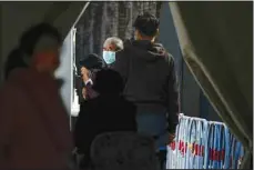  ?? (AP) ?? Residents wearing face masks line up to get their routine COVID-19 throat swabs at a coronaviru­s testing site at a public park in Beijing, Oct. 10.